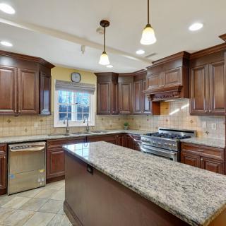 Spacious kitchen with dark wood cabinets and granite countertops.