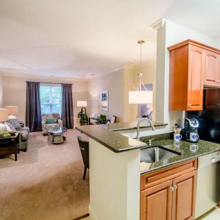 A modern open floor plan featuring a cozy living room and adjacent kitchen area.