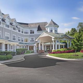 A large residential building with a circular driveway and landscaped gardens.