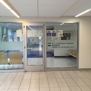 Entrance to a facility with glass doors and a visible waiting area.
