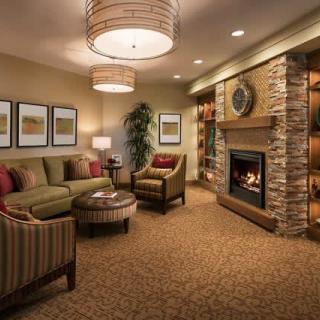 A cozy living room with a modern design featuring comfortable seating, a fireplace, and warm lighting.