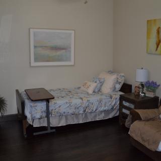 A cozy bedroom with a single bed, nightstand, and artwork on the walls.