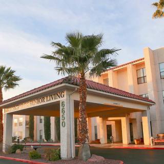 A hotel entrance surrounded by palm trees in a sunny setting.