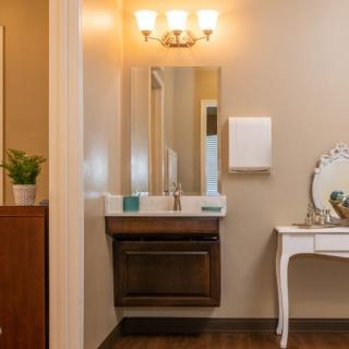 A neatly designed bathroom with a classic vanity and mirror setup.