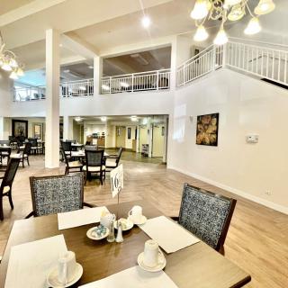 A spacious and elegantly decorated dining area with neatly arranged tables and chairs.