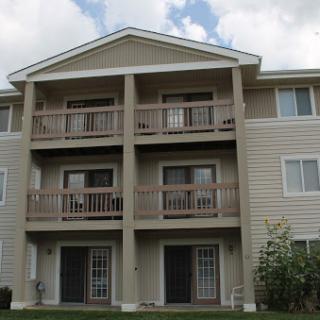 A multi-story apartment building featuring balconies on each level.