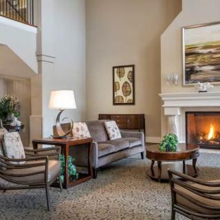 A cozy living room with a fireplace, featuring comfortable seating and warm lighting.
