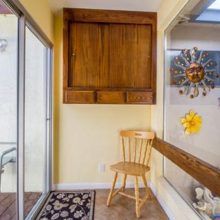 A cozy corner featuring a wooden chair, cabinet, and sun-themed decorations.