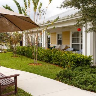 A cozy patio area with outdoor seating, surrounded by a well-maintained garden.