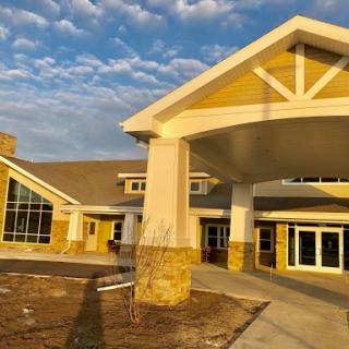 A modern building featuring a welcoming entrance, illuminated by the warm glow of sunset.