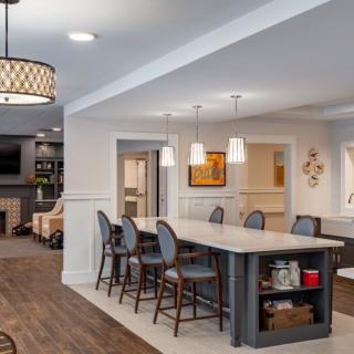 A modern open-concept kitchen and dining area with an island counter and stylish bar stools.