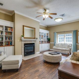A cozy living room with a fireplace, bookshelves, and comfortable seating.