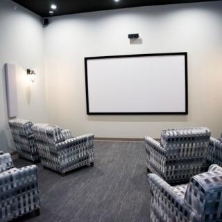 A modern home theater with comfortable seating and a large projector screen.