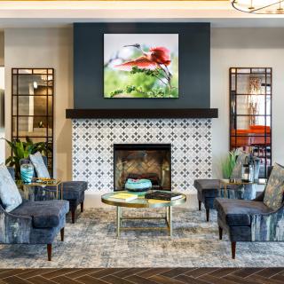 A stylish living room featuring a fireplace, comfortable seating, and vibrant artwork.