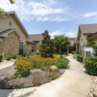 A well-maintained residential area featuring landscaped gardens and a winding pathway between modern houses.