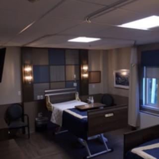 A well-furnished hospital room with a bed and modern amenities.