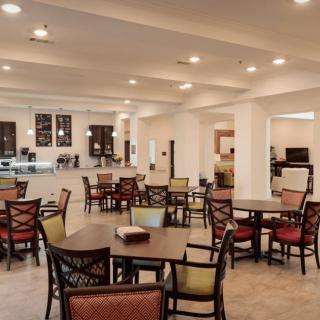 A spacious indoor cafe with a variety of seating arrangements and warm lighting.