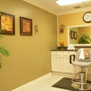 A well-decorated salon interior featuring a styling chair, large mirror, and decorative elements on the walls.