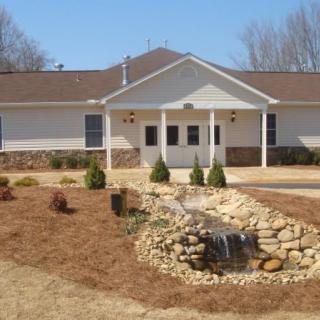 A single-story house with a landscaped front yard and stone garden feature.