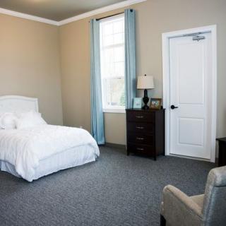 A minimalist bedroom with a single bed and simple furnishings.