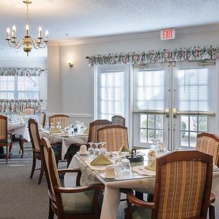 A well-lit dining room with elegant table settings and comfortable seating.