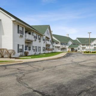 A view of a residential apartment complex with a parking lot in front.