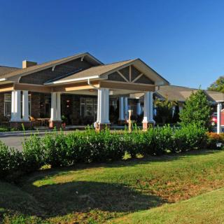 A well-maintained building with a landscaped garden and a welcoming entrance under a clear blue sky.