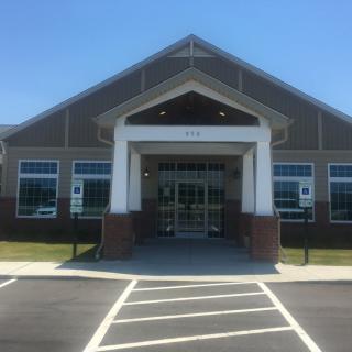 A modern commercial building with a prominent entrance under a clear blue sky.