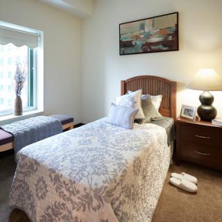 A cozy and well-decorated bedroom featuring a single bed, stylish decor items, and natural light from the window.