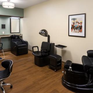A well-equipped hair salon interior featuring chairs, a sink, and a hair dryer.