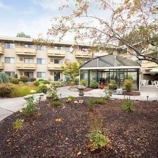 A residential building with a landscaped garden and greenhouse.