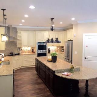A modern kitchen with an island, pendant lights, and stainless steel appliances.