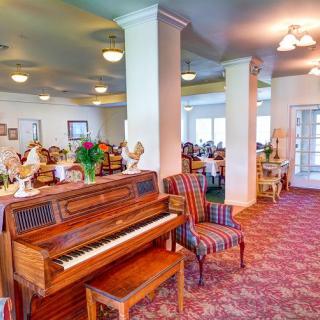 A spacious dining area featuring a piano and comfortable seating arrangements.
