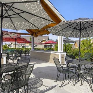 An outdoor patio area with tables, chairs, and umbrellas.