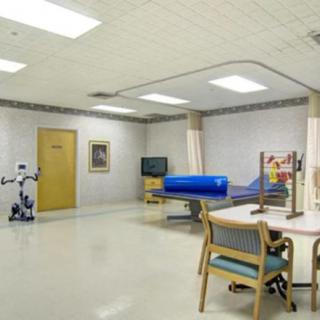 An empty hospital rehabilitation room equipped with therapy and exercise equipment.
