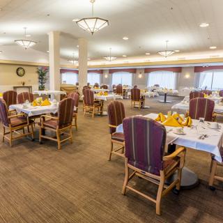 A spacious and elegantly decorated dining area with neatly arranged tables and chairs.