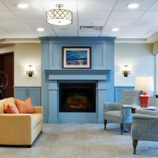 A cozy living room featuring a blue fireplace, comfortable seating, and modern decor.