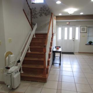 A welcoming entrance featuring a staircase, tiled floor, and a vacuum cleaner for convenience.