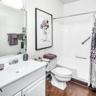 A clean and modern bathroom with a shower, toilet, and sink.