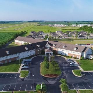 Aerial view of a residential complex surrounded by fields in a countryside setting.