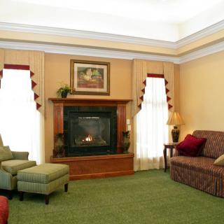 A cozy living room featuring a fireplace, comfortable seating, and elegant decor.