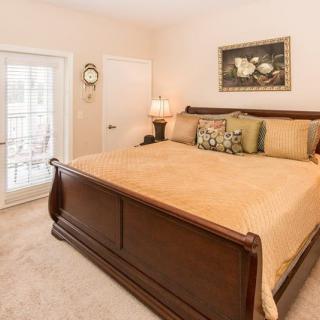A cozy bedroom with a large wooden bed, decorative pillows, and soft lighting.