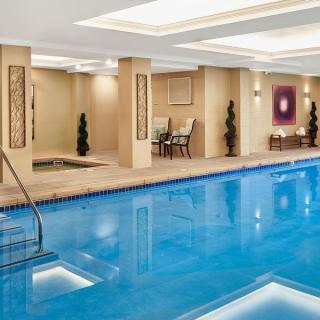 A luxurious indoor swimming pool area with elegant decor and comfortable seating.