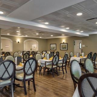 A well-lit dining room with neatly arranged tables and chairs.