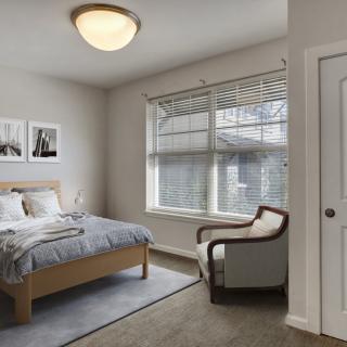 A cozy, well-lit bedroom with modern decor and comfortable furnishings.