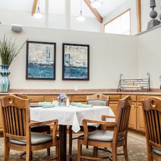 A cozy dining area featuring wooden furniture, tasteful artwork, and a touch of greenery.