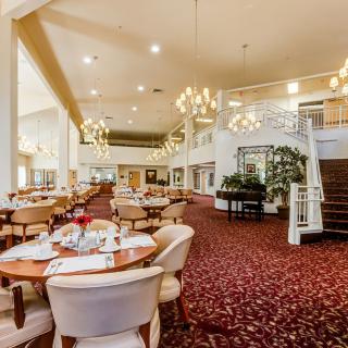 An elegant dining area with chandeliers and neatly arranged tables.