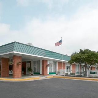 A view of a hospitality building featuring a green roof and an American flag.