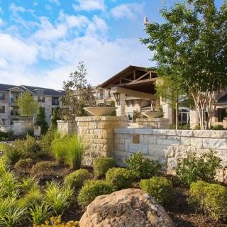 A scenic view of a residential complex surrounded by lush greenery and stone architecture.