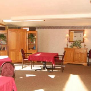 A cozy dining room with tables covered in red tablecloths and wooden furniture.